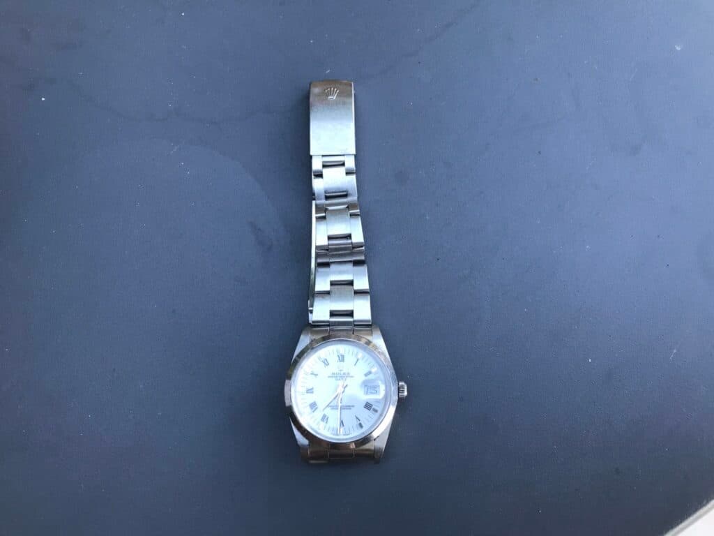 Estimation de la valeur d’une montre Rolex Oyster Perpetual Date en acier inoxydable avec des traces d’usure visibles