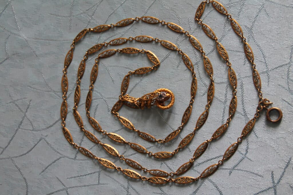 Estimation d’un sautoir en or filigrané avec bride serpent sertie Estimation d’un sautoir en or filigrané avec bride serpent sertie