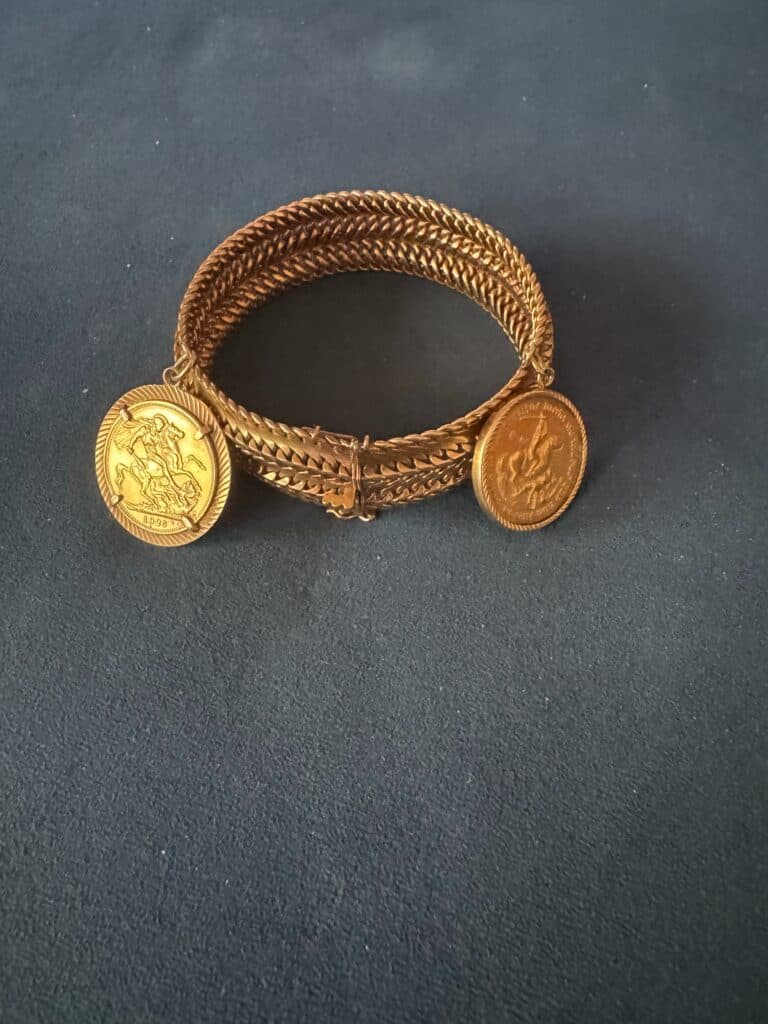 Estimation d’un bracelet en mailles dorées avec pendentifs en forme de pièce Estimation d’un bracelet en mailles dorées avec pendentifs en forme de pièce